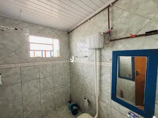 Interior de um cômodo com paredes de azulejo e janela.