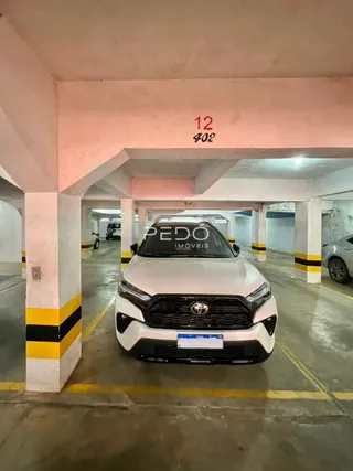 Foto de um corredor interno com uma caminhonete estacionada.