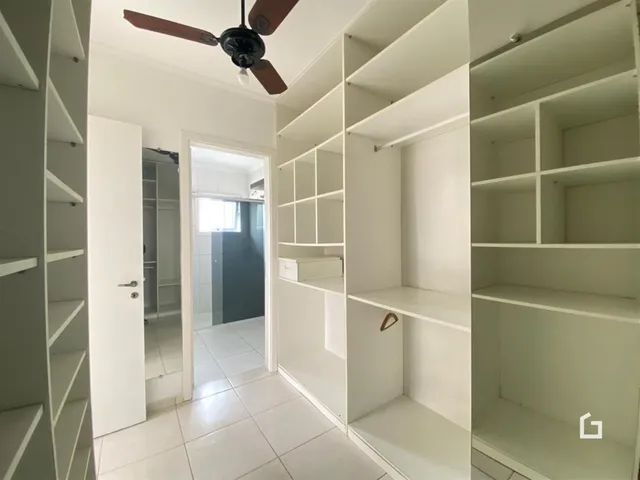 Hall de entrada com estantes brancas.