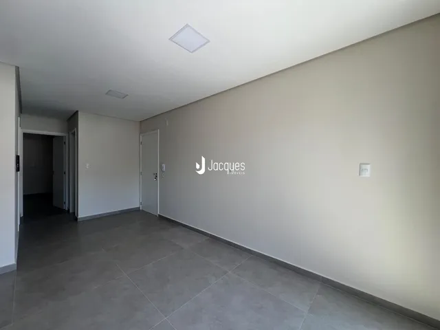 Hall de entrada com piso de cerâmica e paredes claras.