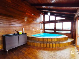 Interior com revestimento de madeira e banheira em um ambiente residencial.