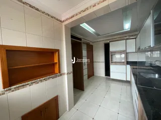 Hall de entrada com revestimento de cerâmica branca e armários de madeira.