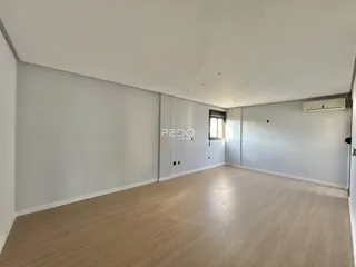Ambiente interno de uma sala com piso claro e paredes brancas.