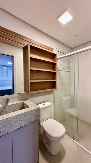 Foto de um banheiro moderno com revestimento de piso claro e box de vidro.