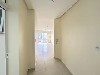 Foto de um corredor interno de uma residência com piso de cerâmica.