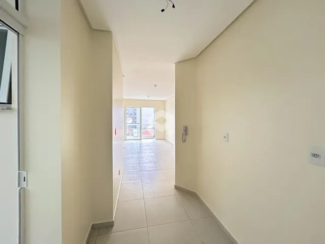 Foto de um corredor interno de uma residência com piso de cerâmica.