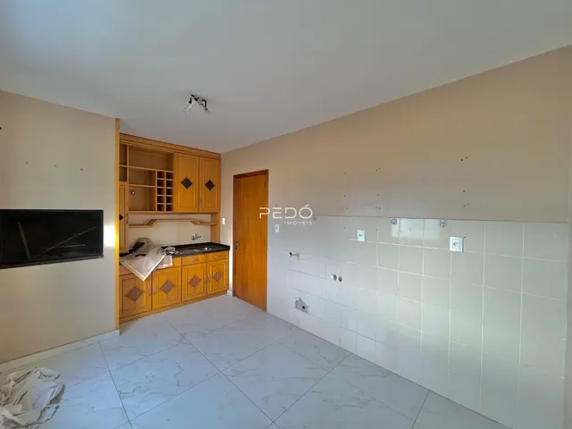 Foto de uma cozinha com armários de madeira e piso de cerâmica.