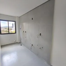 Foto de um ambiente interno com paredes claras e uma janela.