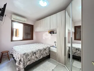 Quarto com cama e armários brancos em um imóvel.