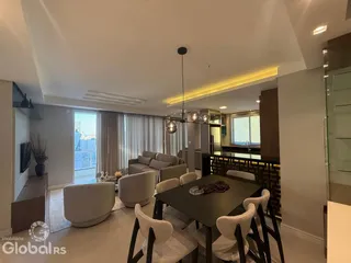 Sala de estar com sofá e mesa de jantar em um apartamento no Brasil.