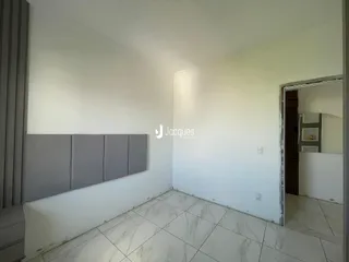 Quarto com paredes brancas e piso de porcelanato claro.