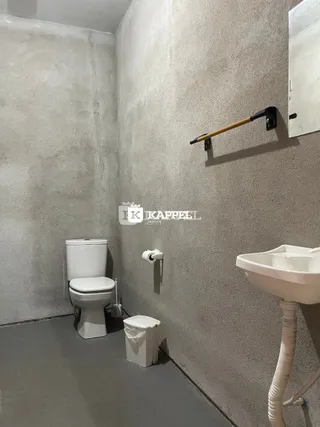 Foto interna de um banheiro mostrando um vaso sanitário e uma pia.