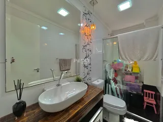 Banheiro moderno com pia e box de vidro.