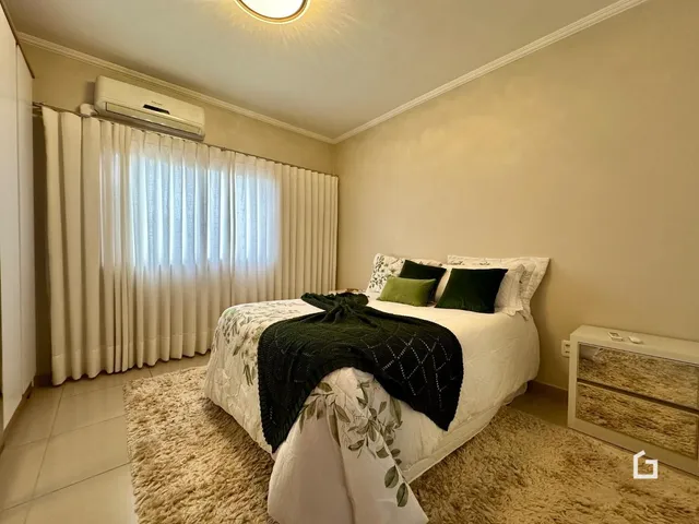 Quarto com cama e cortinas brancas.