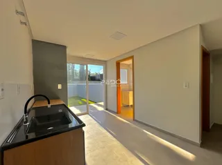 Interior de uma sala com porta de vidro abrindo para o jardim.