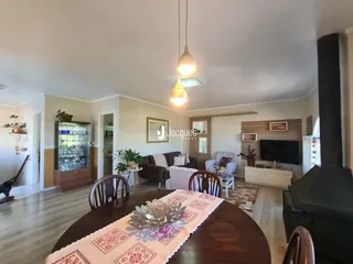 Sala de estar com mesa de jantar e lareira em imóvel em Lajeado.