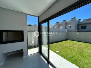 Vista do quintal de uma residência em Lajeado, Brasil, com grandes portas de vidro.