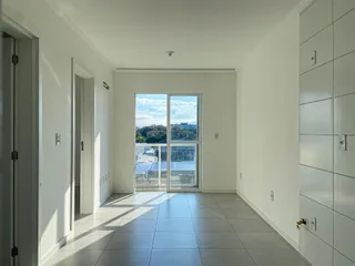 Hall de entrada com piso claro e porta de vidro que dá para a vista externa.