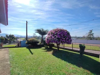 Vista externa de um jardim gramado com vegetação e cerca em Lajeado.