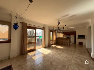 Sala de estar ampla com piso de cerâmica e portas de vidro.
