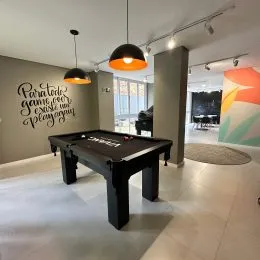 Foto de uma mesa de tênis de mesa em uma área comum de um imóvel.
