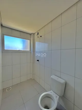Foto de um banheiro com revestimento cerâmico branco.
