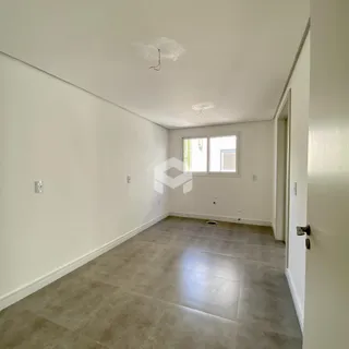 Vista interna de um ambiente com paredes brancas e piso de cerâmica.