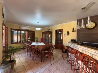 Foto de uma sala de jantar com mesa de madeira e piso de cerâmica.