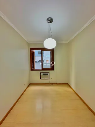 Vista de um corredor interno com piso de madeira clara.