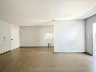 Ambiente interno amplo com paredes brancas e piso de cerâmica.