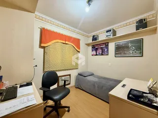 Quarto com cama e decoração de parede em ambiente residencial.