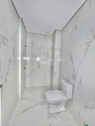 Foto de um banheiro com revestimento em mármore branco.