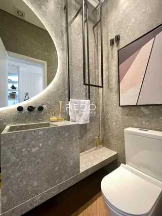 Detalhe da bancada e vaso sanitário de um banheiro.