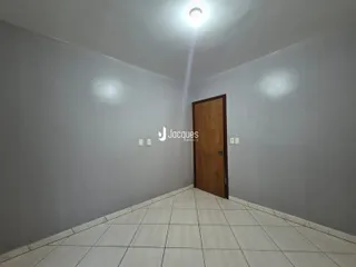 Hall de corredor com paredes cinzas claras e piso de cerâmica branca.