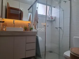 Banheiro moderno com box de vidro e bancada de madeira.