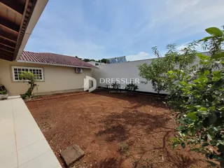 Vista externa da casa e do terreno com solo de terra.