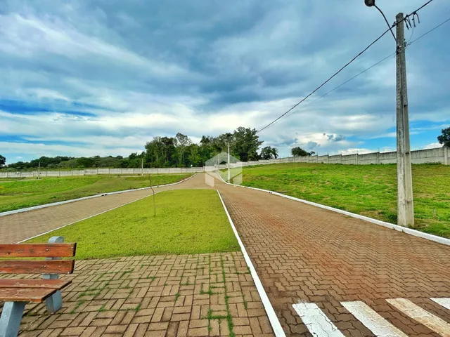 Vista externa da propriedade com gramado e caminho de acesso.