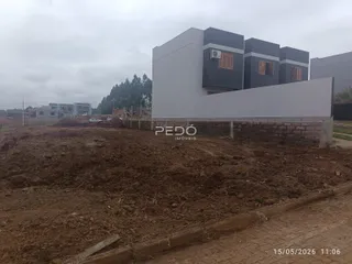 Fachada de uma residência moderna em construção com terreno aberto na frente.