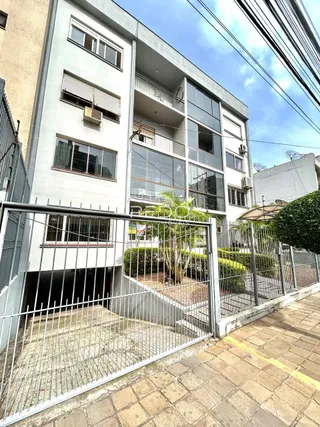 Fachada de um prédio residencial em Lajeado, Brasil, com grade de segurança na frente.