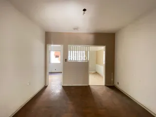 Hall de entrada com piso de madeira e paredes brancas.
