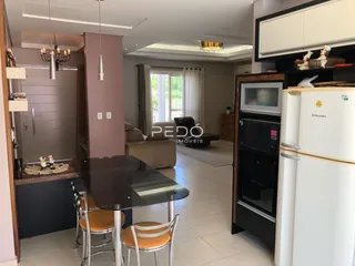 Ambiente de sala de jantar com móveis e cozinha moderna em Lajeado.