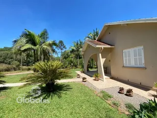 Foto da fachada de uma residência em Lajeado, Brasil, com jardim verde.
