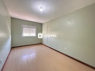 Foto de uma sala com piso de madeira clara e paredes de cor verde clara.