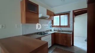 Foto de uma cozinha com armários de madeira e bancadas claras.