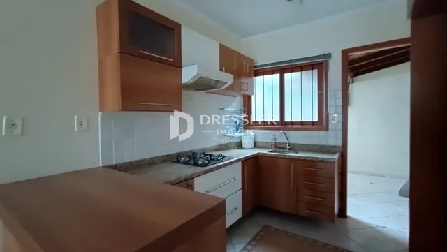 Foto de uma cozinha com armários de madeira e bancadas claras.