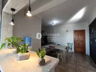 Interior de uma sala de estar com área de jantar em um imóvel em Lajeado.