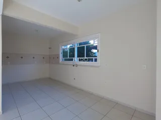 Espaço interno com piso de cerâmica e parede revestida.