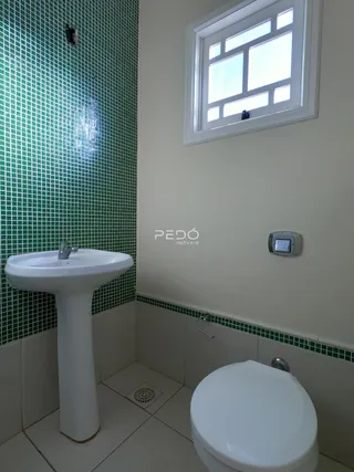 Foto de um banheiro com revestimento de azulejos verdes e brancos.
