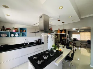 Cozinha moderna com armários brancos e bancadas pretas em Lajeado.