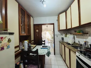 Interior da cozinha com armários de madeira e piso cerâmico.